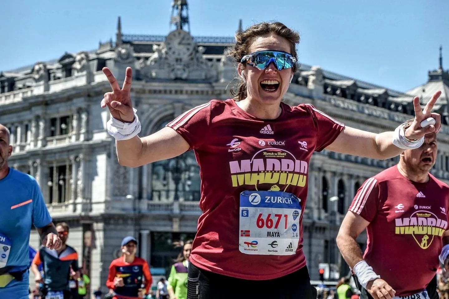 Maya løper maraton i Madrid og viser seierstegn med begge hendene.